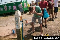 A festival goers pours water on his head at a water station, on the third day of Glastonbury Festival near Somerset, England, June 28, 2019.