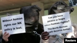 Former North Korean defectors, who have been living in South Korea since their escape from the North, hold signs during a rally in Seoul, Nov. 2009.