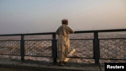 FILE - A man watches as water is discharged at a dam in Jhang, Pakistan, Sept. 10, 2014. Ground was broken Friday on an $81 million U.S.-funded component of a dam project in Pakistan's volatile tribal area of North Waziristan.