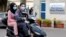 People wearing face masks ride on a motorbike outside Rafik Hariri hospital, where Lebanon's first coronavirus case is being quarantined, in Beirut, Lebanon, Feb. 21, 2020. 
