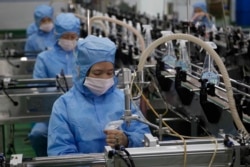 FILE - Workers of the Ryongaksan Soap Factory make disinfectant in Pyongyang, North Korea, March 19, 2020.