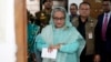 FILE - Sheikh Hasina checks her watch as she waits for the official opening time to cast her vote in Dhaka, Bangladesh, Jan. 7, 2024.