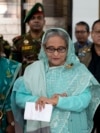 FILE - Sheikh Hasina checks her watch as she waits for the official opening time to cast her vote in Dhaka, Bangladesh, Jan. 7, 2024.