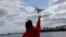 FILE- A drone operator helps to retrieve a drone after photographing over Hart Island in New York, April 29, 2018.