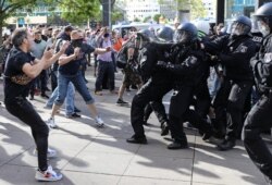 Police officers pepper-spray protesters during a demonstration at Alexanderplatz, amid the spread of the coronavirus disease, in Berlin, Germany, May 9, 2020.