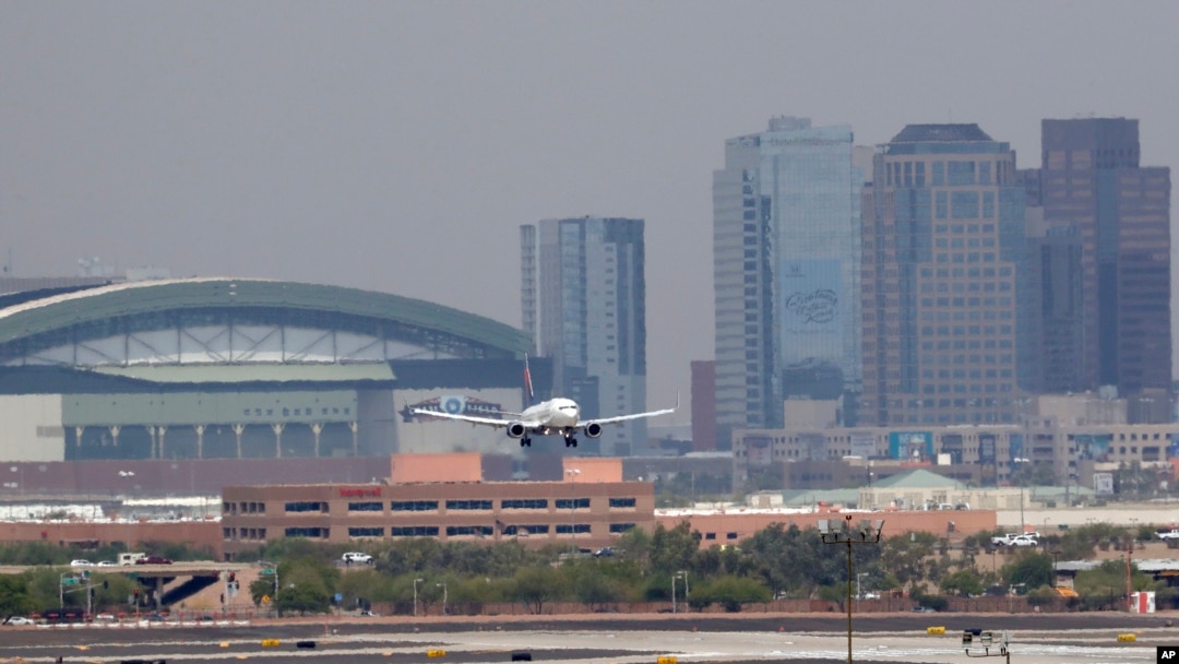 Gelombang panas terlihat di sekitar tarmac Bandara Internasional Sky Harbor dengan latar belakang pusat kota Phoenix saat sebuah pesawat mendarat, 20 Juni 2017. Seorang anak lagi ditemukan meninggal setelah ditinggalkan di mobil di tengah suhu yang sangat panas di kota Phoenix. (Foto:dok)