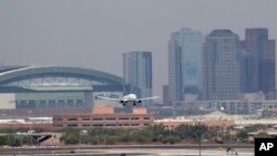 Gelombang panas terlihat di sekitar tarmac Bandara Internasional Sky Harbor dengan latar belakang pusat kota Phoenix saat sebuah pesawat mendarat, 20 Juni 2017. Seorang anak lagi ditemukan meninggal setelah ditinggalkan di mobil di tengah suhu yang sangat panas di kota Phoenix. (Foto:dok)