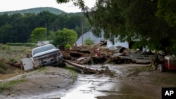 Los escombros en una propiedad agrícola son destruidos en Canisteo, Nueva York, el 9 de agosto de 2024, después de que los restos de la tormenta tropical Debby arrasaran el área.