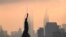La Statue de la Liberté est vue devant l'Empire State Building au lever du soleil le 9 juillet 2020 à New York.