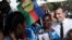 French President Emmanuel Macron, right, meets residents, one with the independence Kanak flag in her hair, on Ouvea Island, off New Caledonia, May 5, 2018.