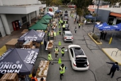Volunteers load up vehicles at a food distribution center in the Crenshaw district of Los Angeles, April 17, 2020. Food banks in the state have seen a spike in numbers as the state's unemployment level has jumped.