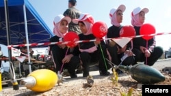 FILE - Schoolchildren attend an awareness campaign teaching them to identify mines and unexploded cluster bombs at the United Nations Interim Force in Lebanon (UNIFIL) headquarters in the town of Naqoura in southern Lebanon, April 4, 2014. 