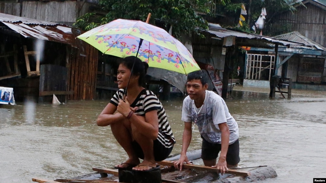 Warga membuat rakit darurat untuk melewati banjir yang disebabkan oleh badai tropis Agaton, di Butuan, bagian selatan pulau Mindanau 19 Januari 2014.