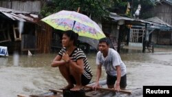 Warga membuat rakit darurat untuk melewati banjir yang disebabkan oleh badai tropis Agaton, di Butuan, bagian selatan pulau Mindanau 19 Januari 2014.