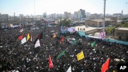 Miles de dolientes en Ahvaz, Irán, rodean un vehículo con los ataúdes cubiertos con banderas que contienen los restos del general Qassem Soleimani y sus camaradas, muertos en un ataque de dron de EE.UU. en Bagdad. 5 de enero de 2020. (Mohammad Mohsenifar/Mehr News Agency via AP) 