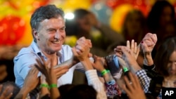 Outgoing Buenos Aires Mayor Mauricio Macri holds hands with followers after a mayoral runoff election — won by conservative candidate Horacio Rodriguez Larreta — in Buenos Aires, July 19, 2015.