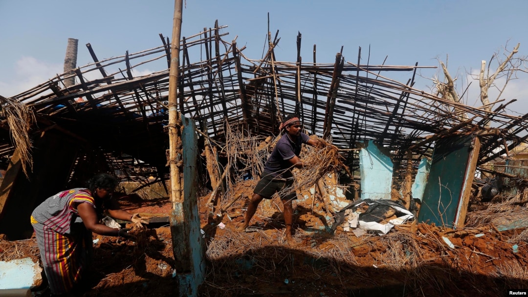 Seorang nelayan dan istrinya membersihkan puing-puing dari rumah mereka yang rusak diterjang topan di Desa Gopalpur di Distrik Ganjam di negara bagian Odisha, di timur India, 14 Oktober 2013.
