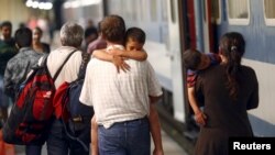 Travelers believed to be migrants leave a train coming from Hungary at the railway station in Vienna, Austria, September 1, 2015. 