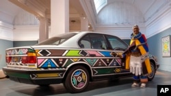FILE - In this image released on Thursday, February, 15, 2024, is South African artist Esther Mahlangu, standing beside her BMW Art Car at Iziko South African National Gallery, 2024.