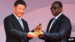 Le président sénégalais Macky Sall a remis au président chinois Xi Jinping une clé de cérémonie lors de l'inauguration de l'arène nationale de lutte, à Dakar, le 22 juillet 2018.