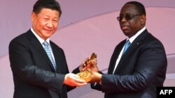 Le président sénégalais Macky Sall a remis au président chinois Xi Jinping une clé de cérémonie lors de l'inauguration de l'arène nationale de lutte, à Dakar, le 22 juillet 2018.