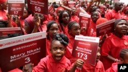 219 anak perempuan Nigeria memegang poster kecil bertuliskan nama 219 siswi Chibok korban penculikan dalam aksi peringatan setahun penculikan di ibukota Abuja, Selasa (14/4).