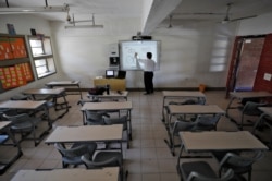 FILE - A teacher leads an online class for his students inside a private school after Gujarat government ordered the closure of schools and colleges across the state amid coronavirus fears, in Ahmedabad, India, March 17, 2020.