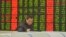 An investor looks at a computer screen showing stock information at a brokerage house in Fuyang, Anhui province, Jan. 28, 2016. 