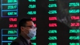 FILE PHOTO: A man wearing a protective mask is seen inside the Shanghai Stock Exchange building, as the country is hit by a new coronavirus outbreak, at the Pudong financial district in Shanghai