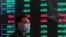 FILE PHOTO: A man wearing a protective mask is seen inside the Shanghai Stock Exchange building, as the country is hit by a new coronavirus outbreak, at the Pudong financial district in Shanghai