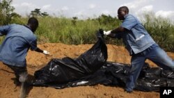 Red Cross workers dump unidentified bodies into a mass grave in Ivory Coast's main city Abidjan (2011 file).