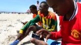FILE - A Somali man browses the internet on his mobile phone at a beach in Somalia's capital Mogadishu, January 10, 2014.
