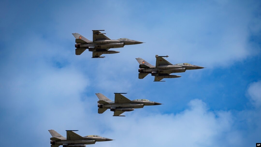Истребители F-16 румынских ВВС и базирующегося в Румынии Европейского учебного центра F-16 (EFTC), который также готовит украинских пилотов, выполняют полет на международной выставке в Бухаресте, Румыния. 22 мая 2024 года. (AP Photo/Vadim Ghirda).