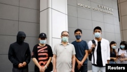 Pro-democracy activists Eddie Chu and Owen Chow with relatives of some of the 12 Hong Kong activists detained at sea, as they reportedly sailed to Taiwan for political asylum, report to the police to seek help in Hong Kong, Sept. 20, 2020.