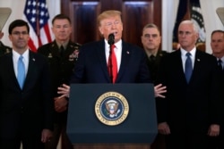President Donald Trump addresses the nation from the White House on the ballistic missile strike that Iran launched against Iraqi air bases housing U.S. troops, Wednesday, Jan. 8, 2020, in Washington, as Vice President Mike Pence and others looks on…