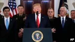 President Donald Trump addresses the nation from the White House on the ballistic missile strike that Iran launched against Iraqi air bases housing U.S. troops, Wednesday, Jan. 8, 2020, in Washington, as Vice President Mike Pence and others looks on…