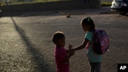The children of Venezuelan migrants Miguel Gonzalez and Maryelis Rodriguez wait for a transportation that will take their family of six to the border with Brazil, in Santa Elena, Venezuela, April 5, 2023.