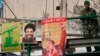 FILE - A Lebanese soldier stands beside posters of Hezbollah leader Sayyed Hassan Nasrallah and Venezuela's President Hugo Chavez on a bridge in Beirut, Dec. 1, 2006. 