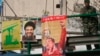 FILE - A Lebanese soldier stands beside posters of Hezbollah leader Sayyed Hassan Nasrallah and Venezuela's President Hugo Chavez on a bridge in Beirut, Dec. 1, 2006. 