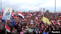 Les partisans du président syrien Bachar al-Assad assistent à un rassemblement dans la ville portuaire du nord de Tartous, en Syrie, 12 janvier 2012.