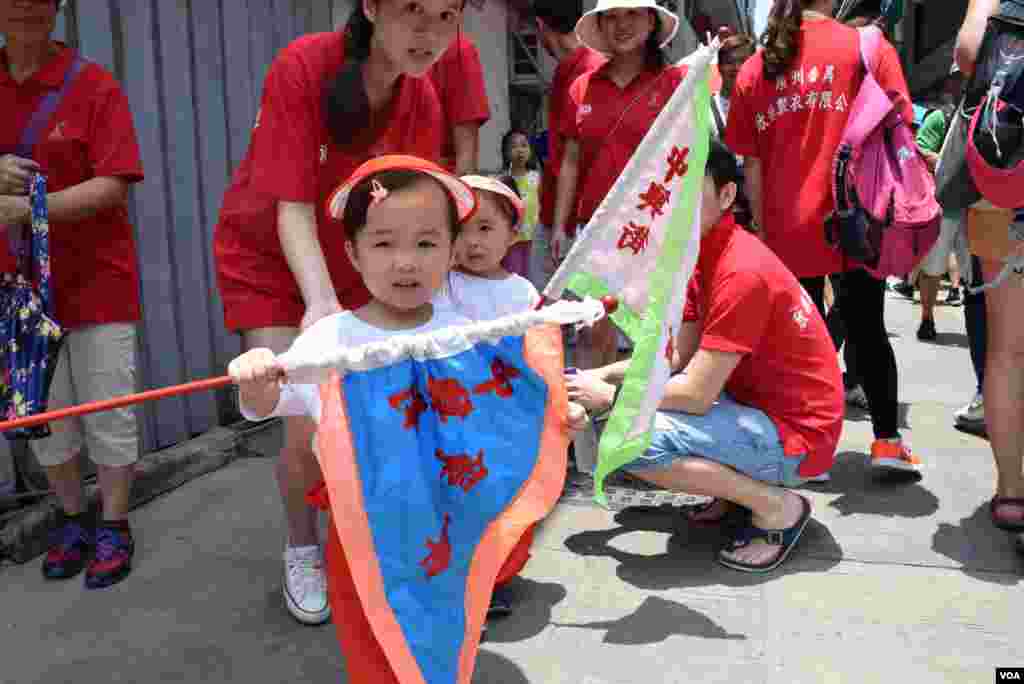 參與飄色巡遊的小女孩手持彩旗。（美國之音湯惠芸攝）