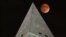 The moon passes behind the peak of the Washington Monument during a lunar eclipse, Sunday, Sept. 27, 2015. Soon visitors will be able to enjoy the view from the top thanks to philanthropist David Rubenstein, who has pledged the funding needed to fix the e