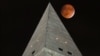 The moon passes behind the peak of the Washington Monument during a lunar eclipse, Sept. 27, 2015. Soon visitors will be able to enjoy the view from the top thanks to philanthropist David Rubenstein, who has pledged the funding needed to fix the monument's elevator, which was forced to shut its doors due to the elevator's mechanical failures. 