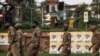 FILE - Security service members wait for the arrival of Ugandan President Yoweri Museveni on his way back from his country home, in Kampala, Uganda, Jan. 21, 2021. 