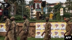 FILE - Security service members wait for the arrival of Ugandan President Yoweri Museveni on his way back from his country home, in Kampala, Uganda, Jan. 21, 2021. 