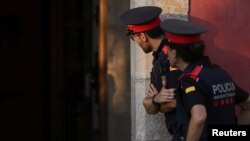 Agentes de policía de los Mossos d'Esquadra se encuentran frente al Parlamento Regional de Cataluña, después de que dos agentes fueran arrestados como parte de una investigación sobre el paradero del líder separatista catalán Carles Puigdemont, en Barcelona.