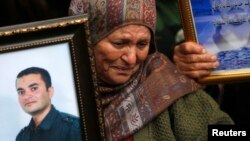 A Palestinian woman holds a picture of a jailed relative during a protest marking "Palestinian Prisoners Day" in the West Bank city of Ramallah, April 17, 2013.