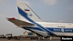 Staf lapangan dan awak pesawat Antonov An-124 Ruslan membongkar tanker Linde setibanya di Bandara Internasional Netaji Subhas Chandra Bose (NSCBIA) di Kolkata, India, 2 Mei , 2021. (REUTERS/Rupak De Chowdhuri)