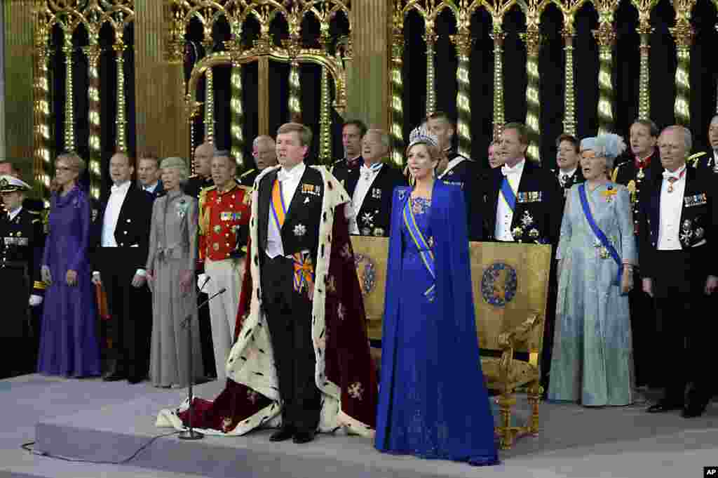Dutch King Willem-Alexander and his wife Queen Maxima, center, sing hymns at the Nieuwe Kerk or New Church in Amsterdam, the Netherlands, prior to his investiture. 