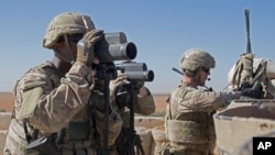 FILE - In this Nov. 1, 2018, photo released by the U.S. Army, soldiers surveil the area during a combined joint patrol in Manbij, Syria. 